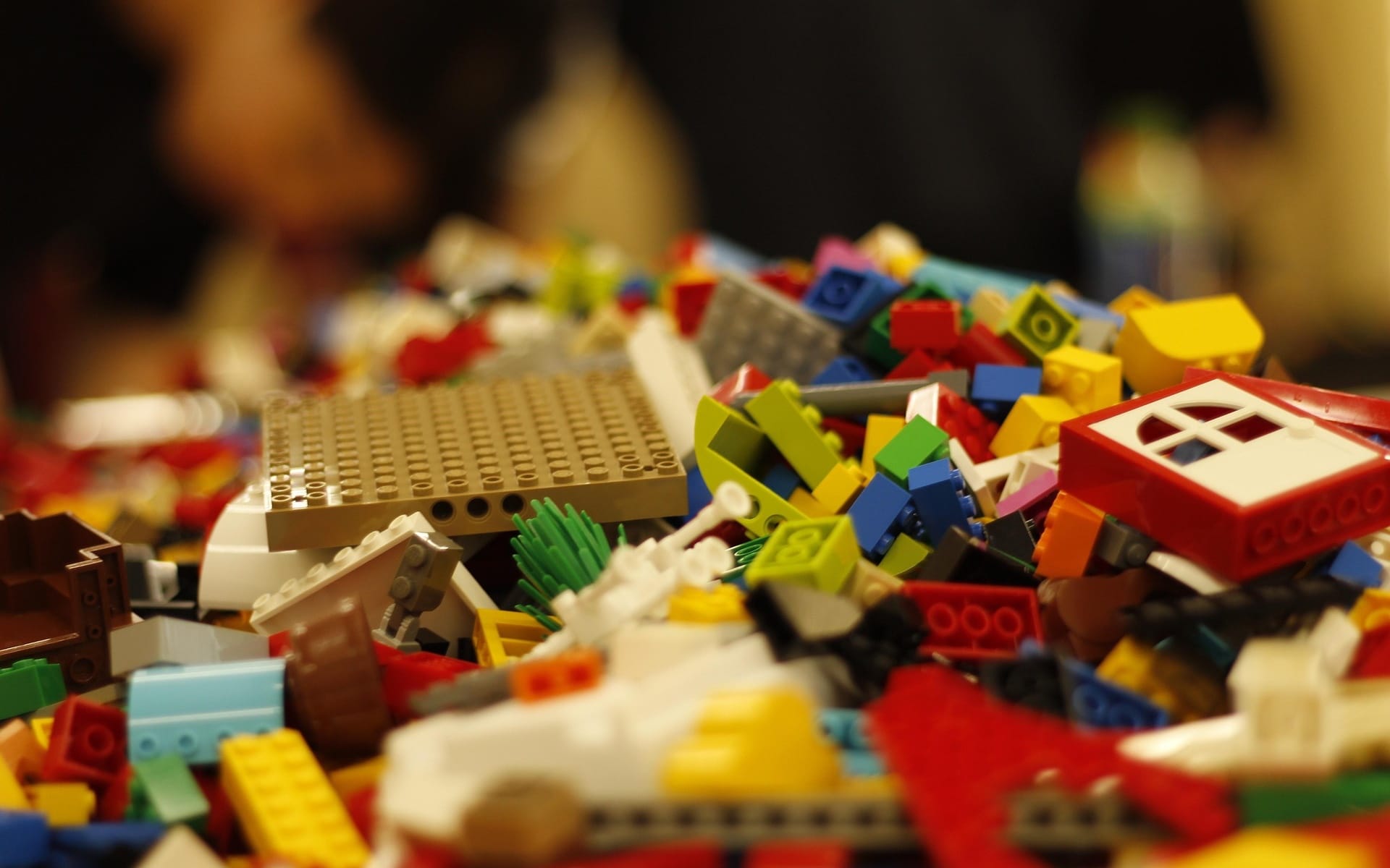 Colorful LEGO bricks scattered showing mix of generic blocks and specialized themed pieces from sets