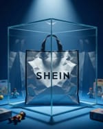 Shein shopping bag locked in a glass box under a spotlight, surrounded by toys.