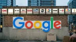 Illuminated news network signs line a wall above a large Google logo, one slot empty, one for rent.