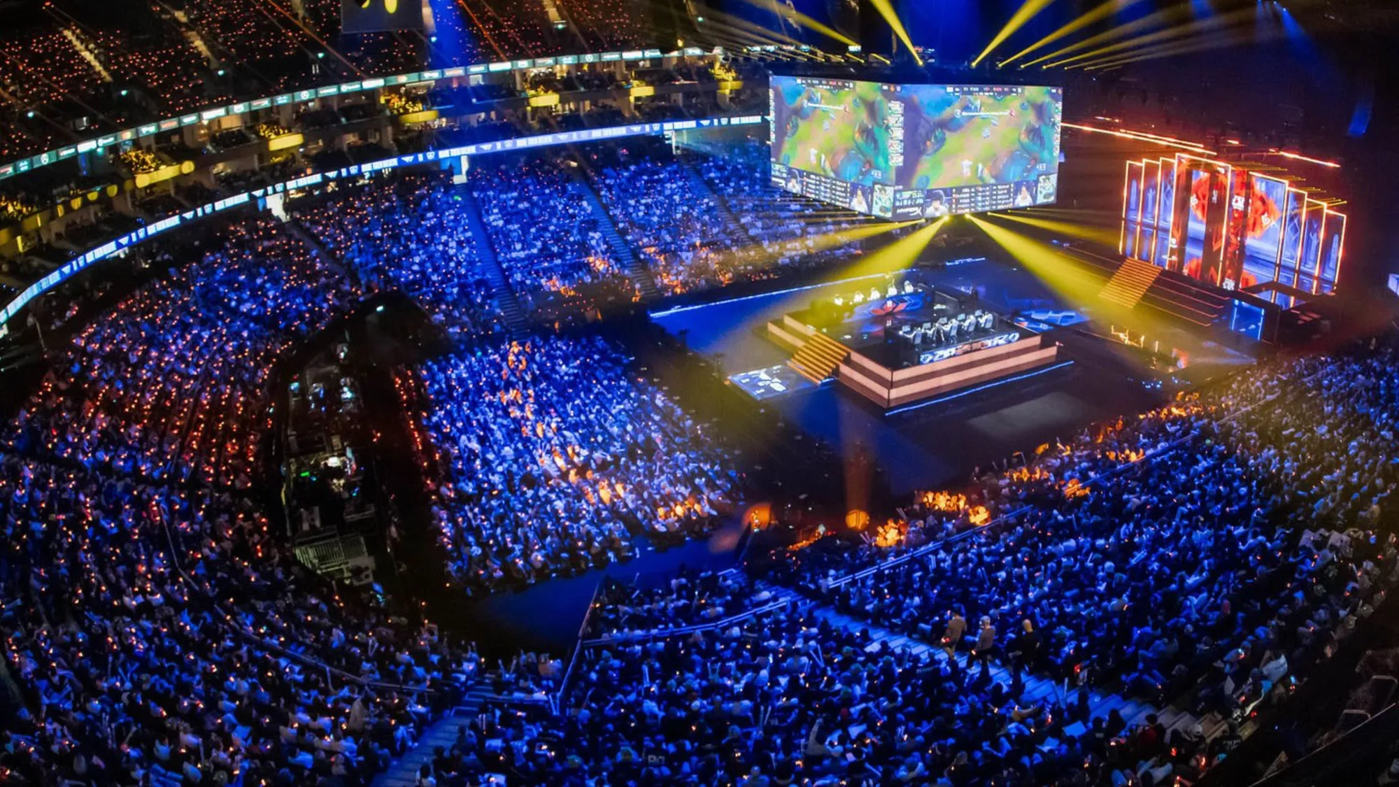 Massive esports arena filled with thousands of fans watching League of Legends tournament on giant screens
