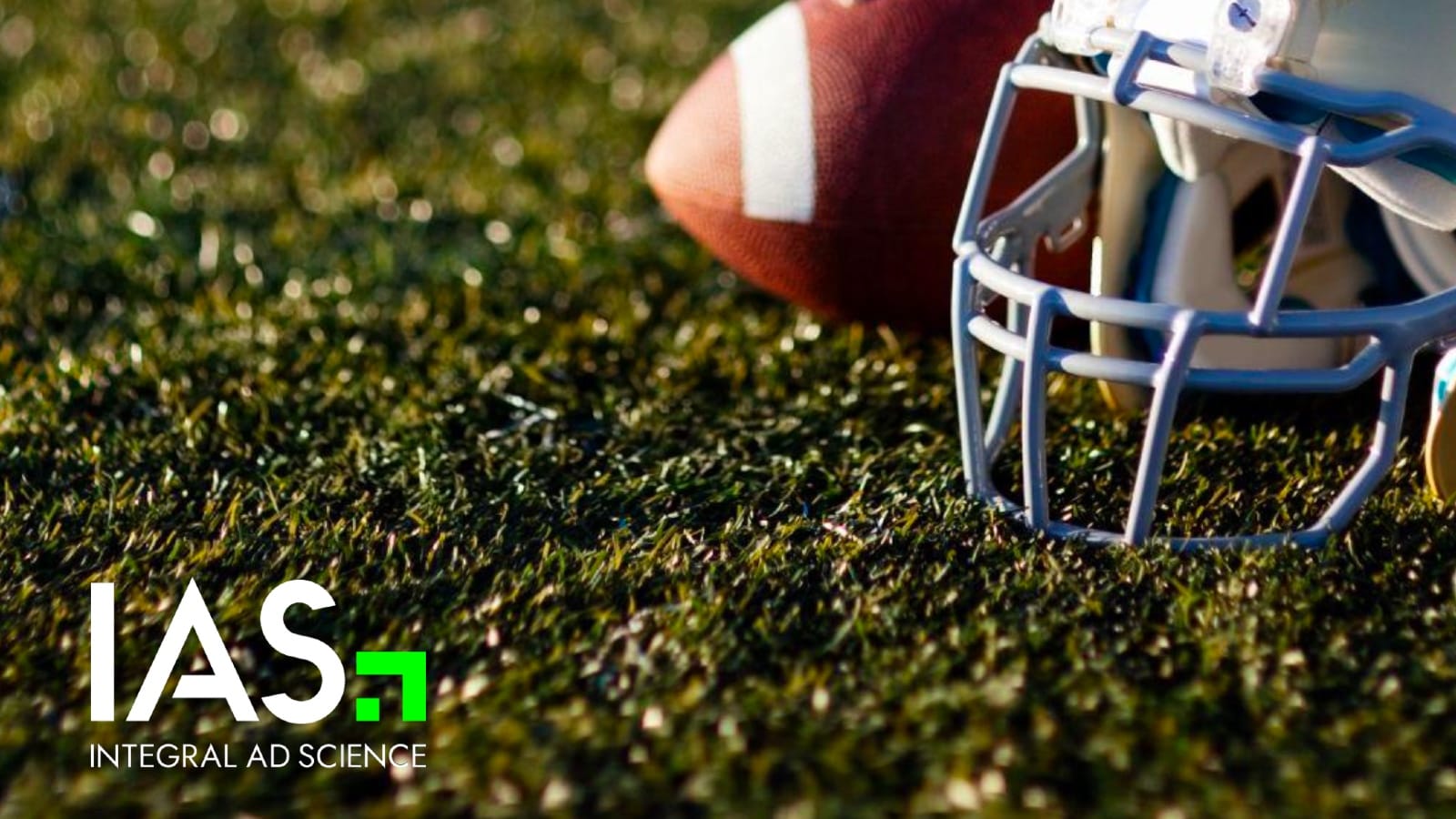 Football helmet and ball on grass highlighting contextual ad targeting for Super Bowl campaigns.