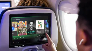 Spotify interface on United Airlines seatback screen showing podcasts and audiobooks in-flight