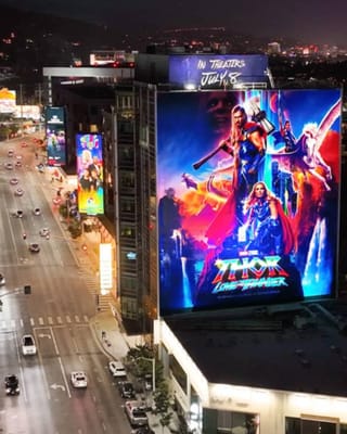 Digital billboards illuminate urban street demonstrating Clear Channel's out-of-home advertising assets