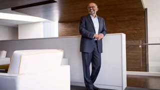 Shantanu Narayen, Adobe CEO, smiling in corporate office, announcing leadership transition in 2026.