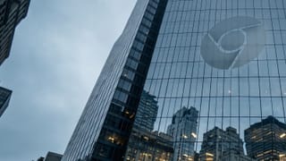 Glass tower reflects trapped city buildings beneath Chrome logo.