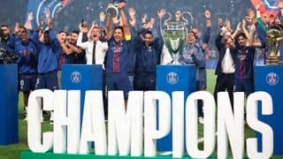 PSG players celebrate with the UEFA Champions League trophy on the pitch