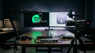 Podcast studio with Spotify and Apple Podcasts logos, microphone, camera, and audio gear.