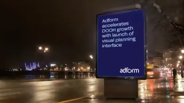 Digital billboard displays Adform's DOOH visual planning interface launch announcement in urban nighttime setting