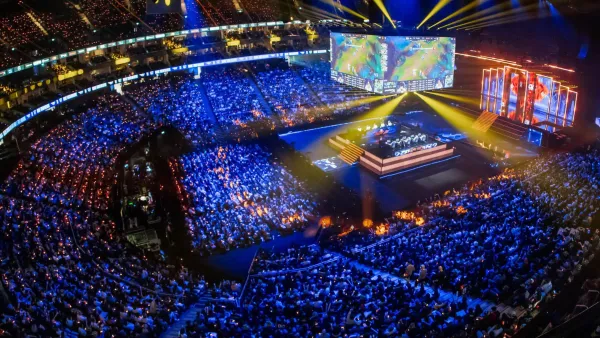 Massive esports arena filled with thousands of fans watching League of Legends tournament on giant screens