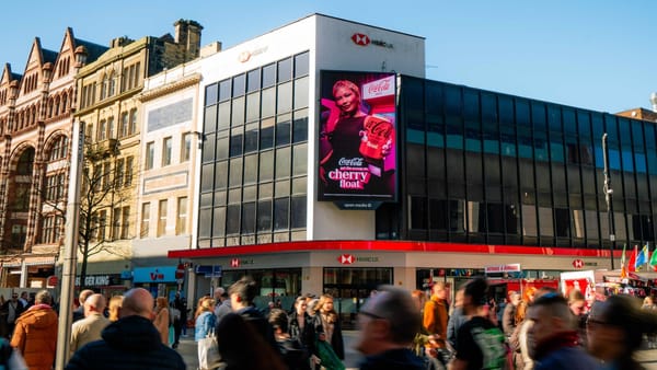 Open Media LED screen displaying a Coca-Cola ad in a busy UK city centre street.