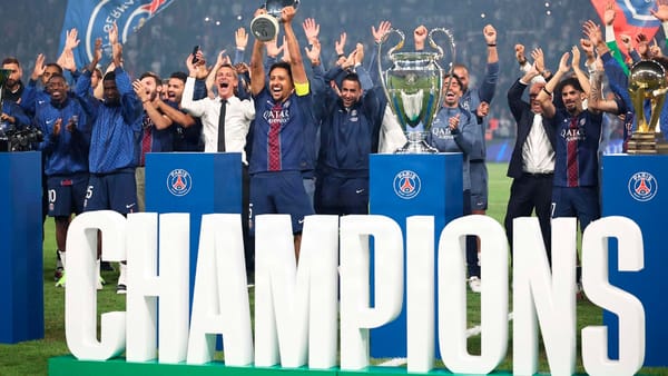 PSG players celebrate with the UEFA Champions League trophy on the pitch