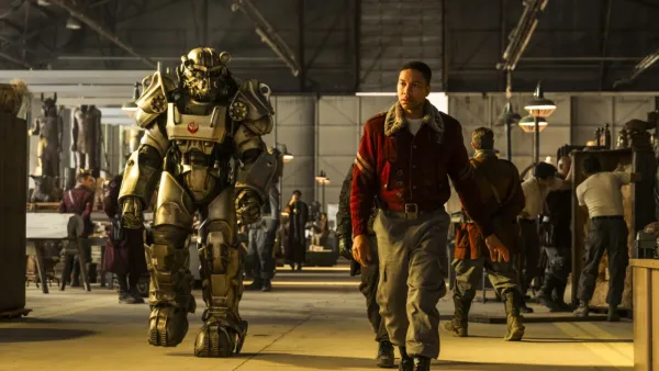 Aaron Moten as Maximus walks alongside Power Armor in Fallout on Prime Video