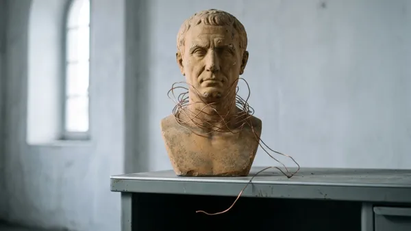 Roman bust with copper wire harness on metal desk, symbolising AI emotion surveillance at work